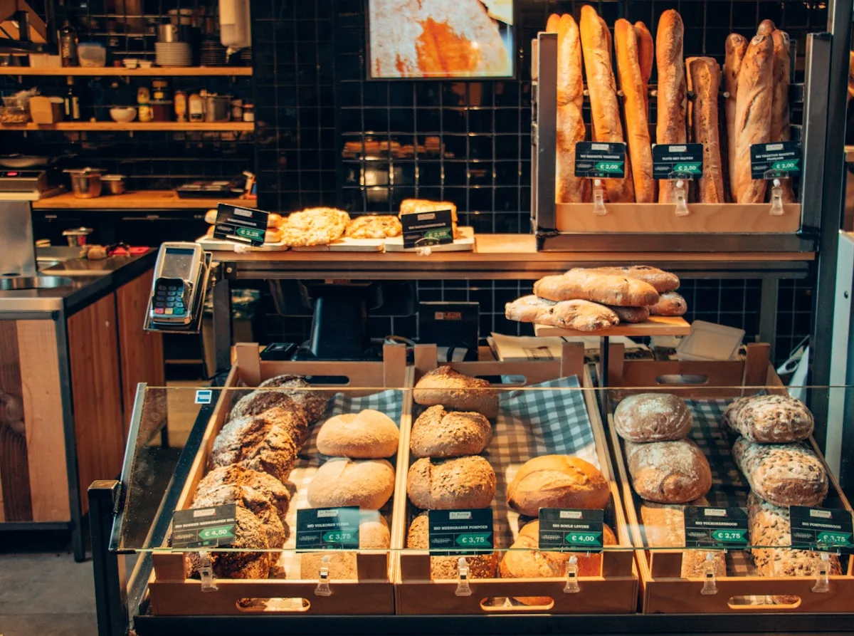 A bakery display case stacked with loaves, rolls and baguettes